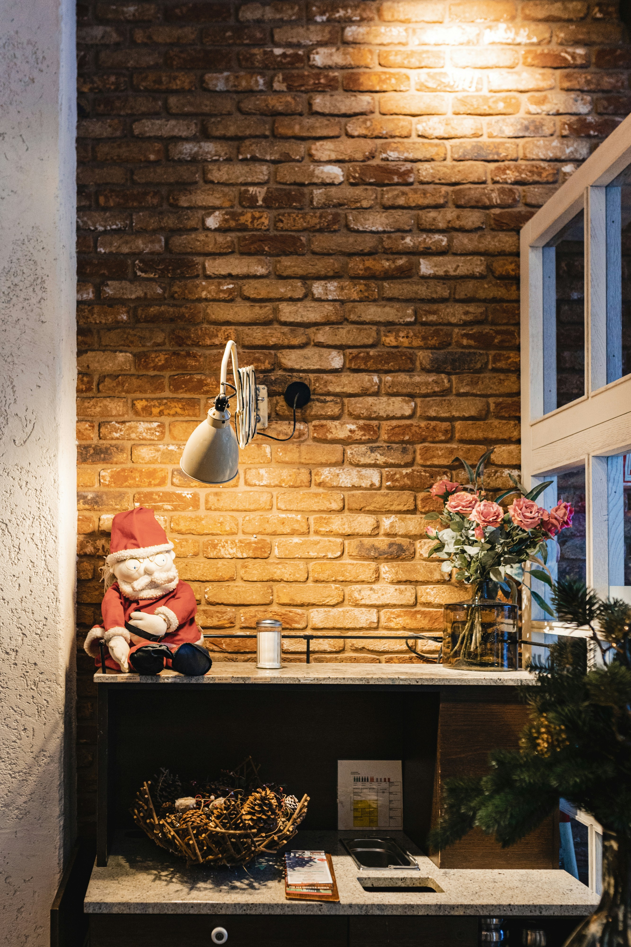 a room with a brick wall and a desk with a lamp on it