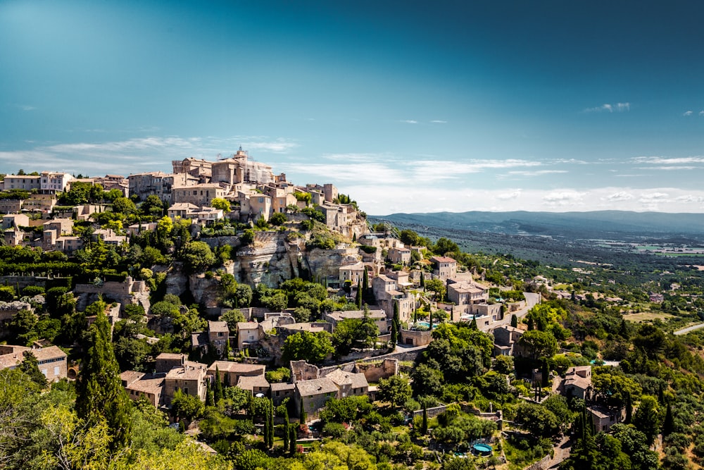 a village on top of a hill surrounded by trees