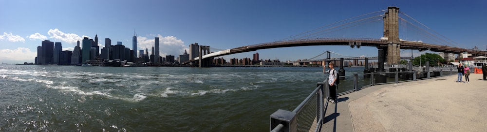 a group of people standing on the side of a bridge