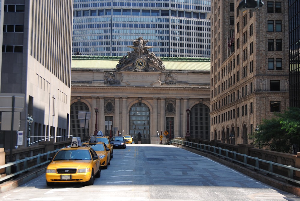 a yellow taxi cab driving down a street next to tall buildings