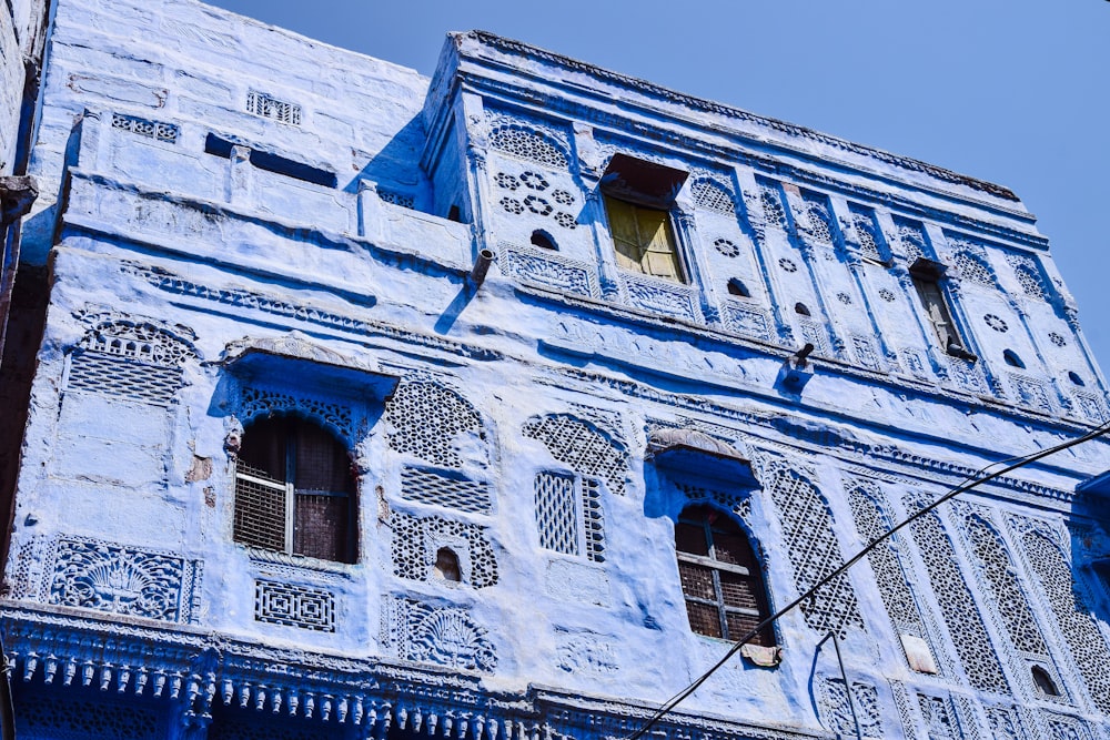 a tall blue building with a clock on it's side