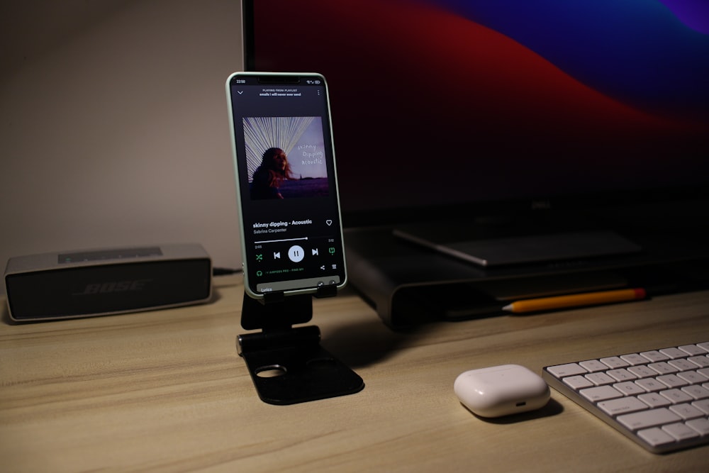 a cell phone sitting on top of a desk next to a keyboard