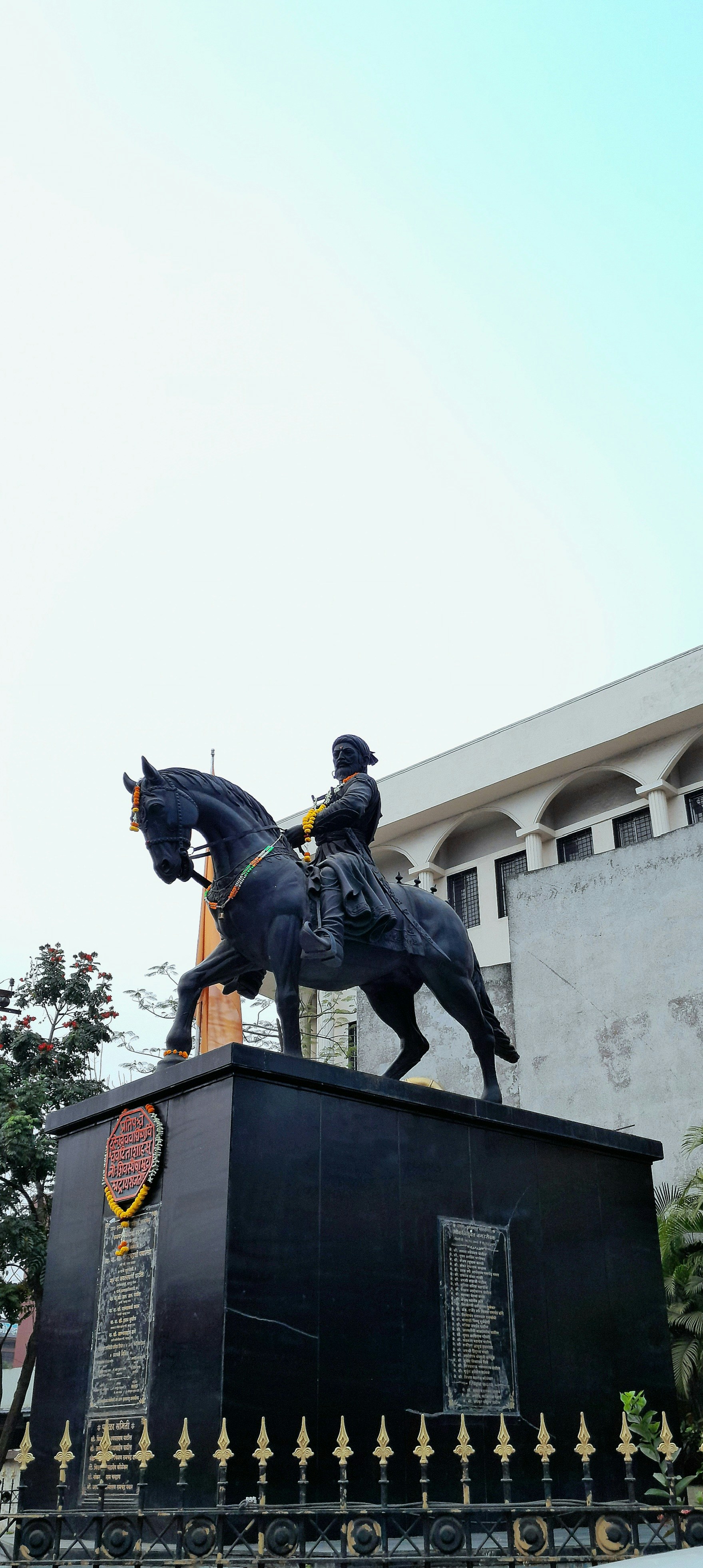 A statue of a man riding a horse in front of a building photo – Free ...