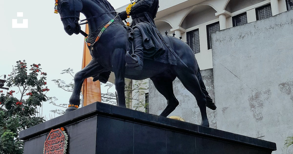 A statue of a man riding a horse in front of a building photo – Free ...