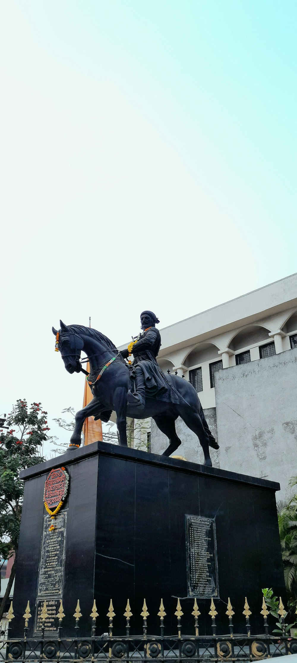 a statue of a man riding a horse in front of a building