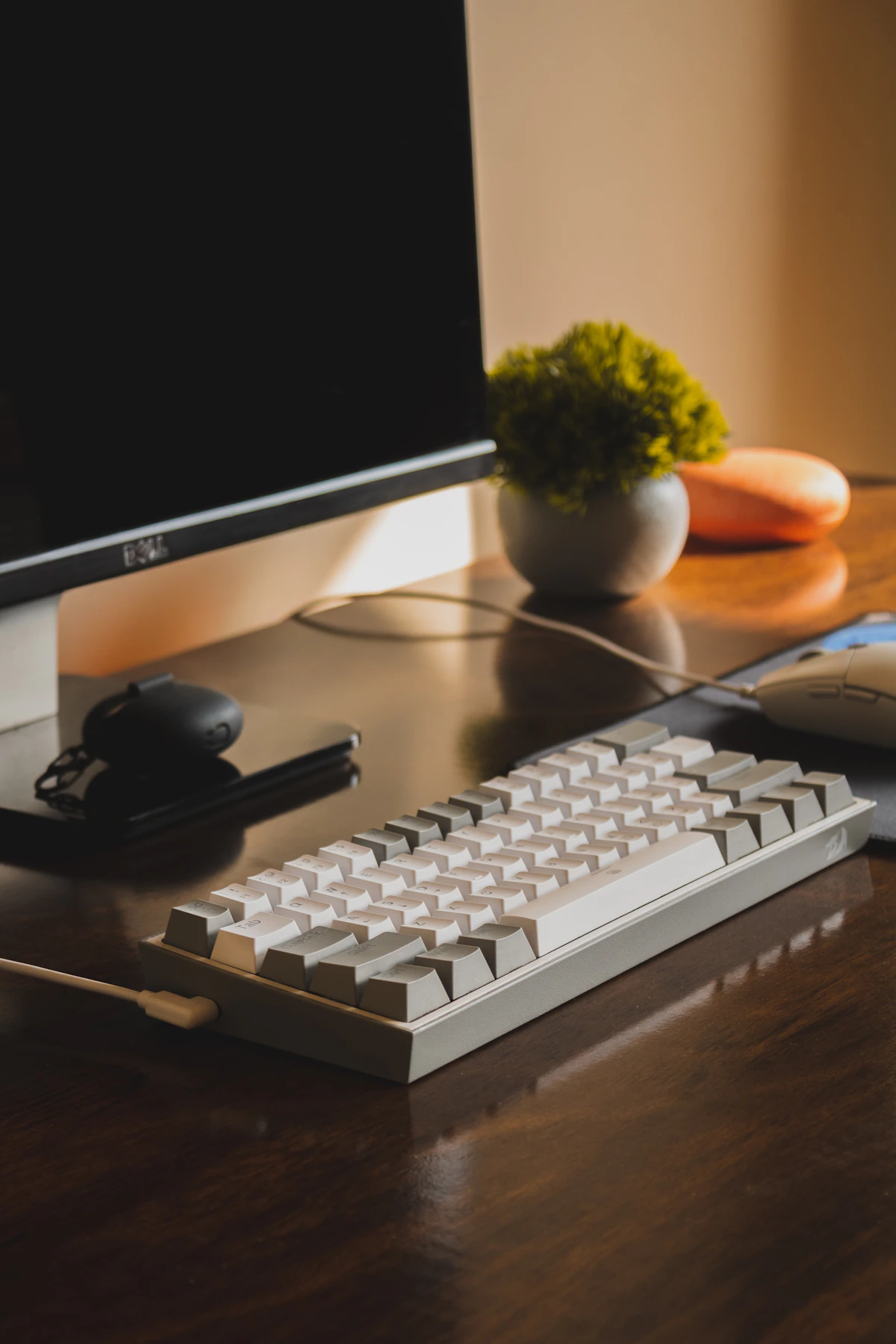 Keyboard, mouse, and computer arranged on a wooden desktop