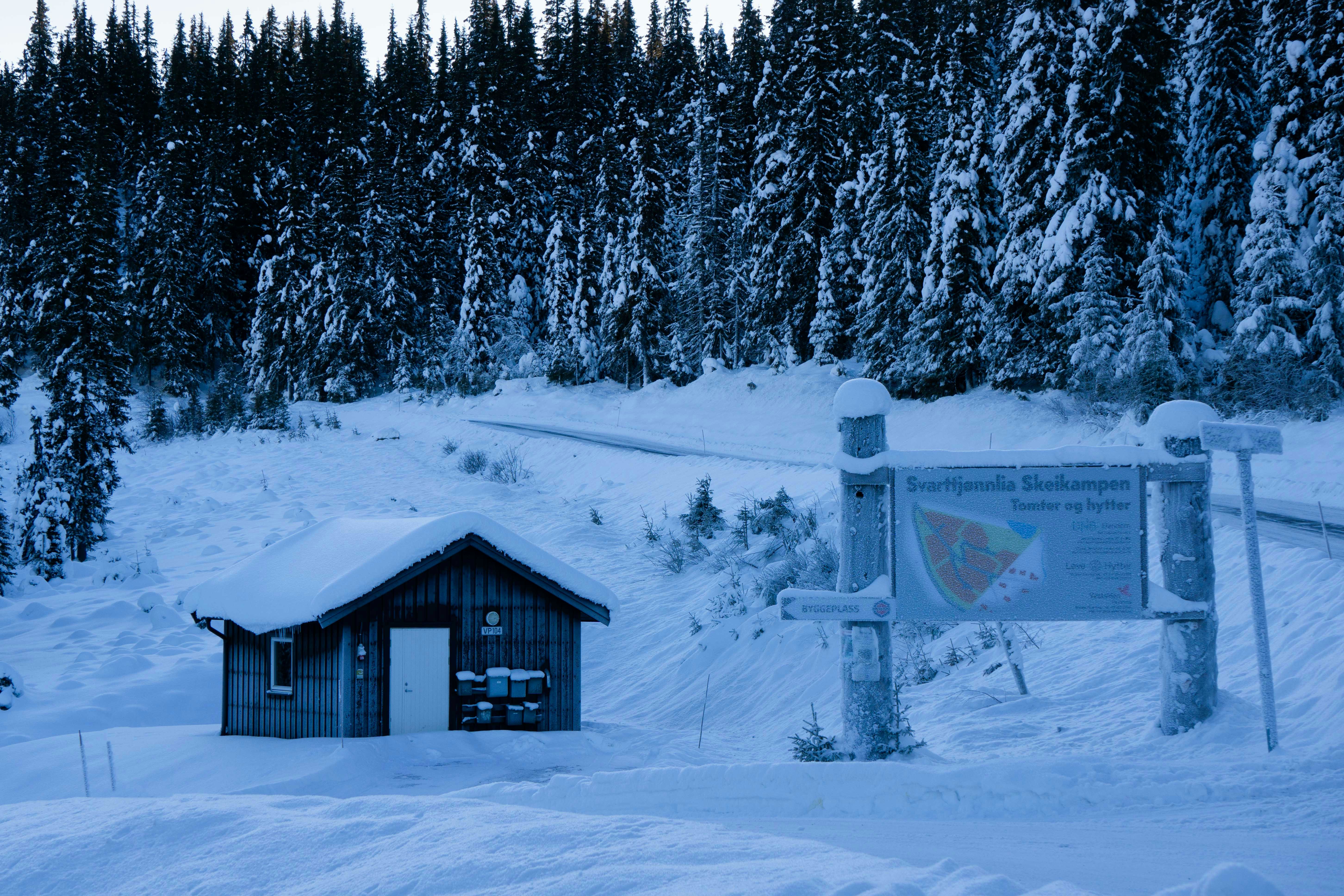 a small cabin in the middle of a snowy field