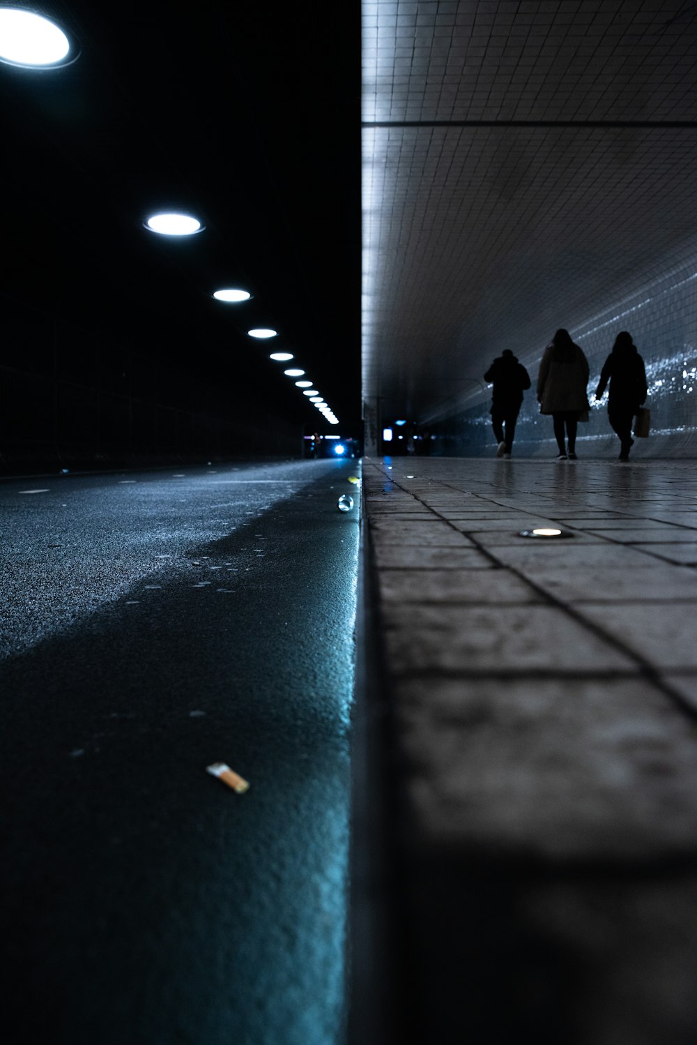 a group of people walking down a walkway at night