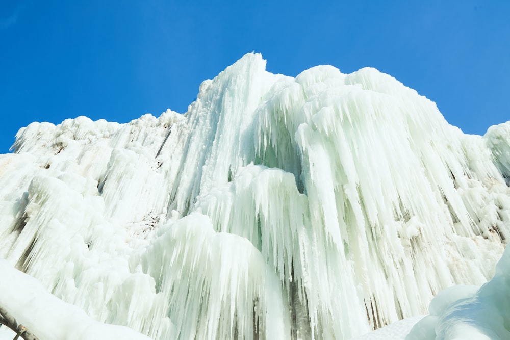 a very tall ice covered mountain under a blue sky