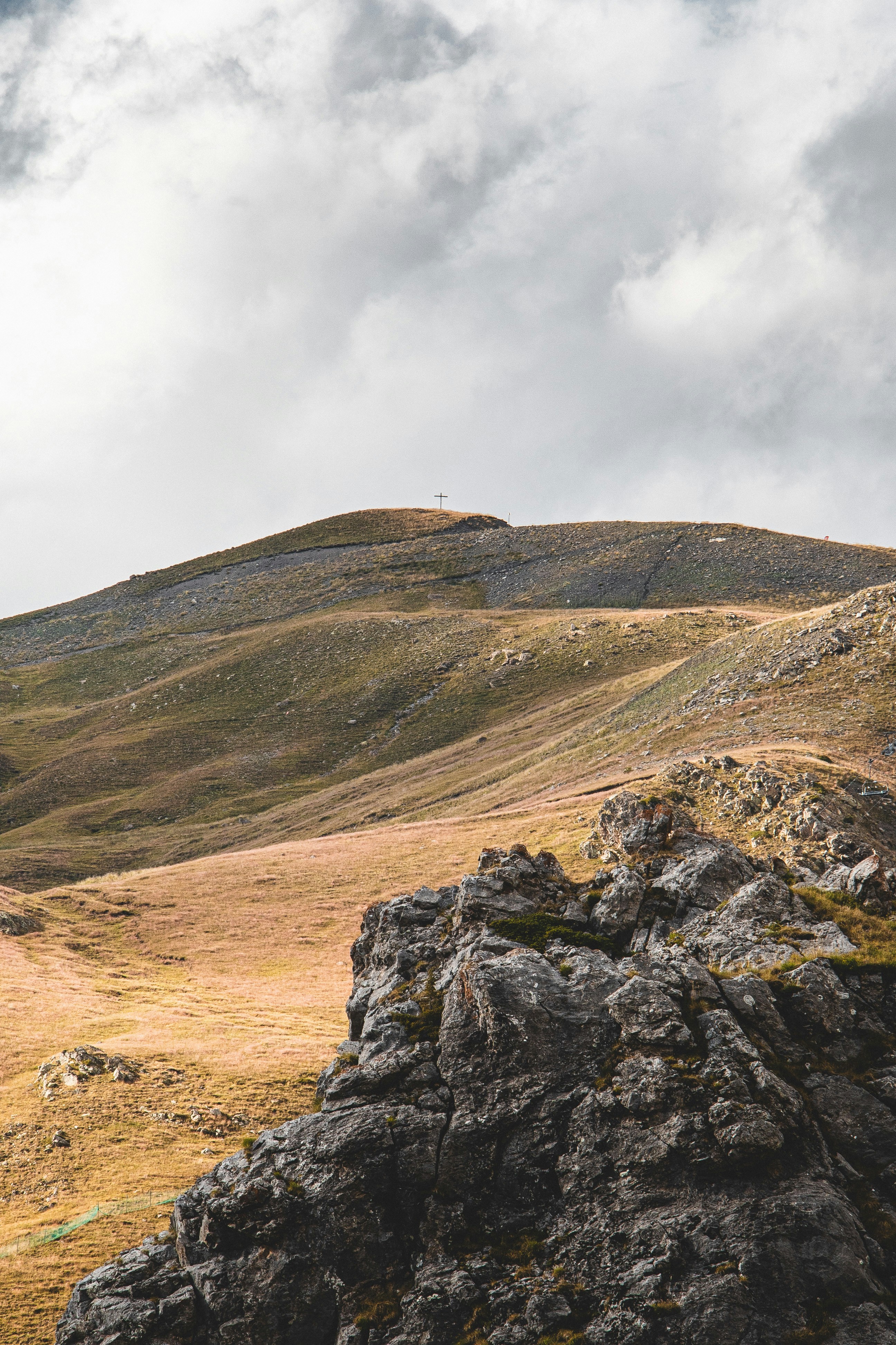Una pecora solitaria in piedi sulla cima di una collina rocciosa