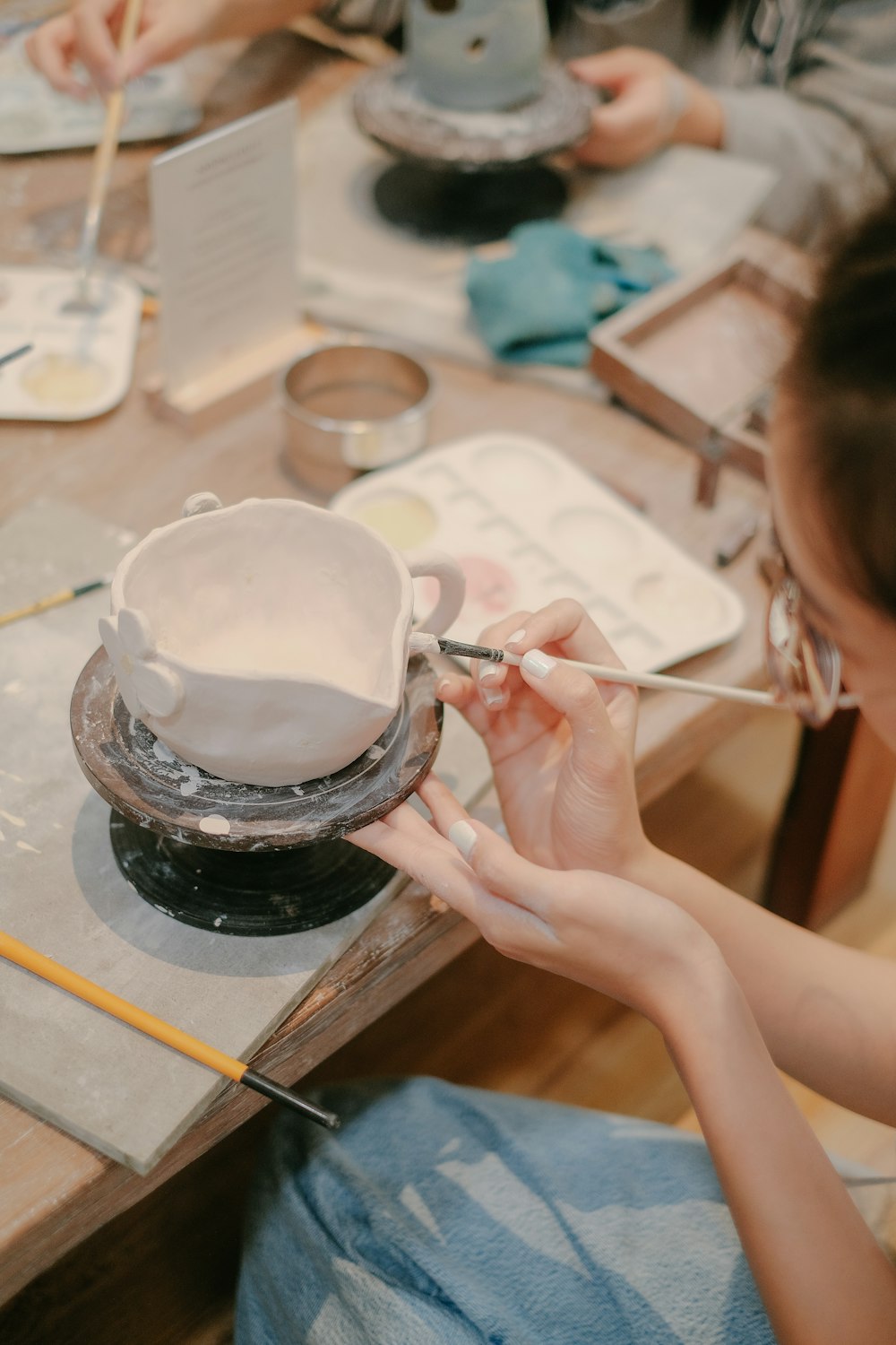 a woman sitting at a table working on a cake