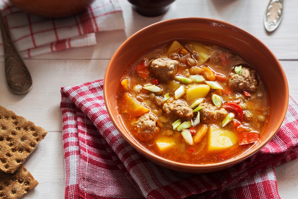 un bol de soupe avec des boulettes de viande et des légumes