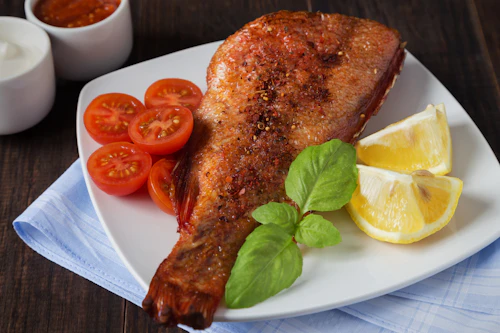 Poisson braisé servi avec une tranche de citron