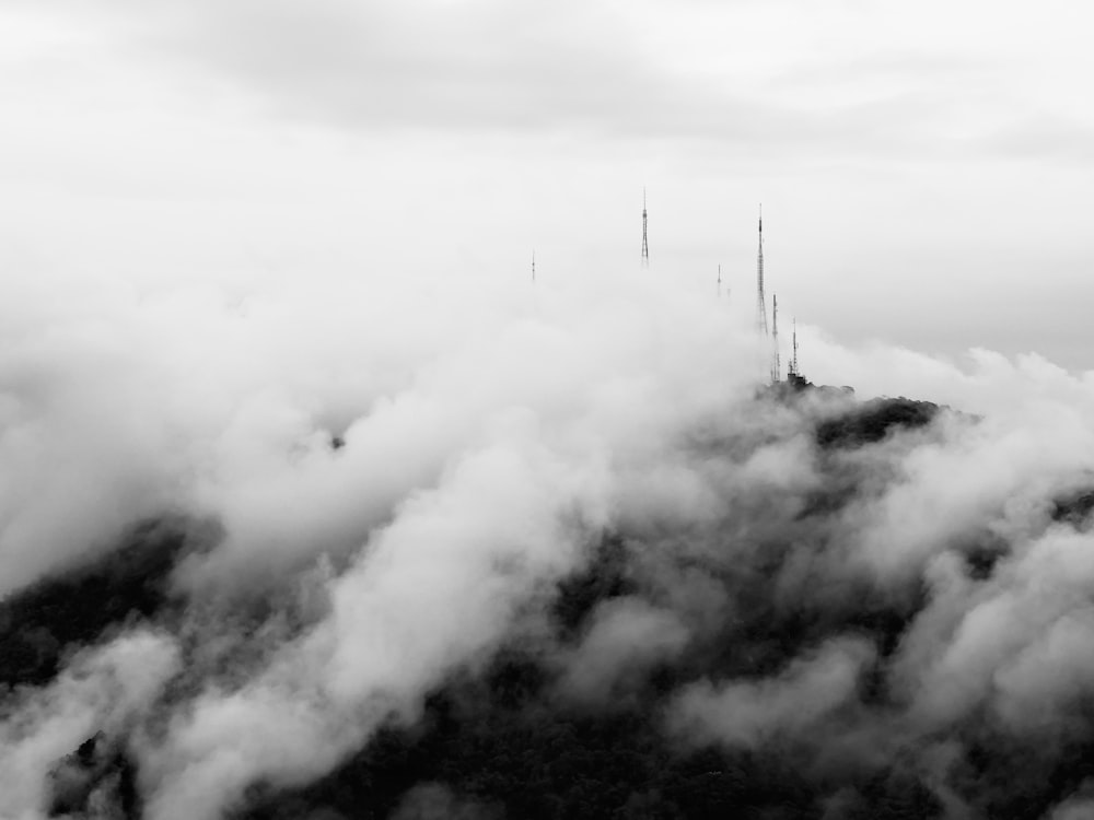 a black and white photo of a mountain covered in clouds