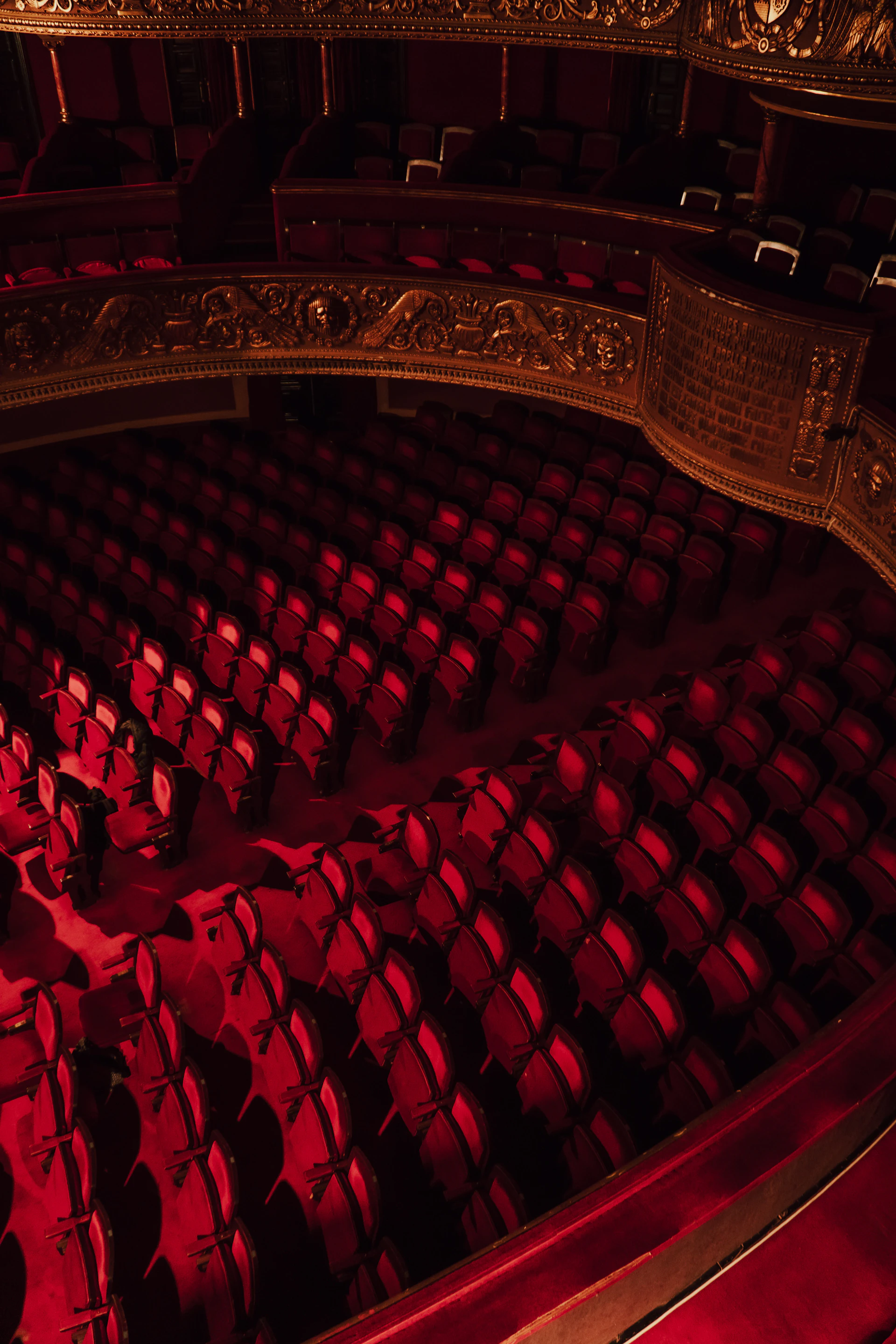 an empty auditorium with red seats and a gold ceiling