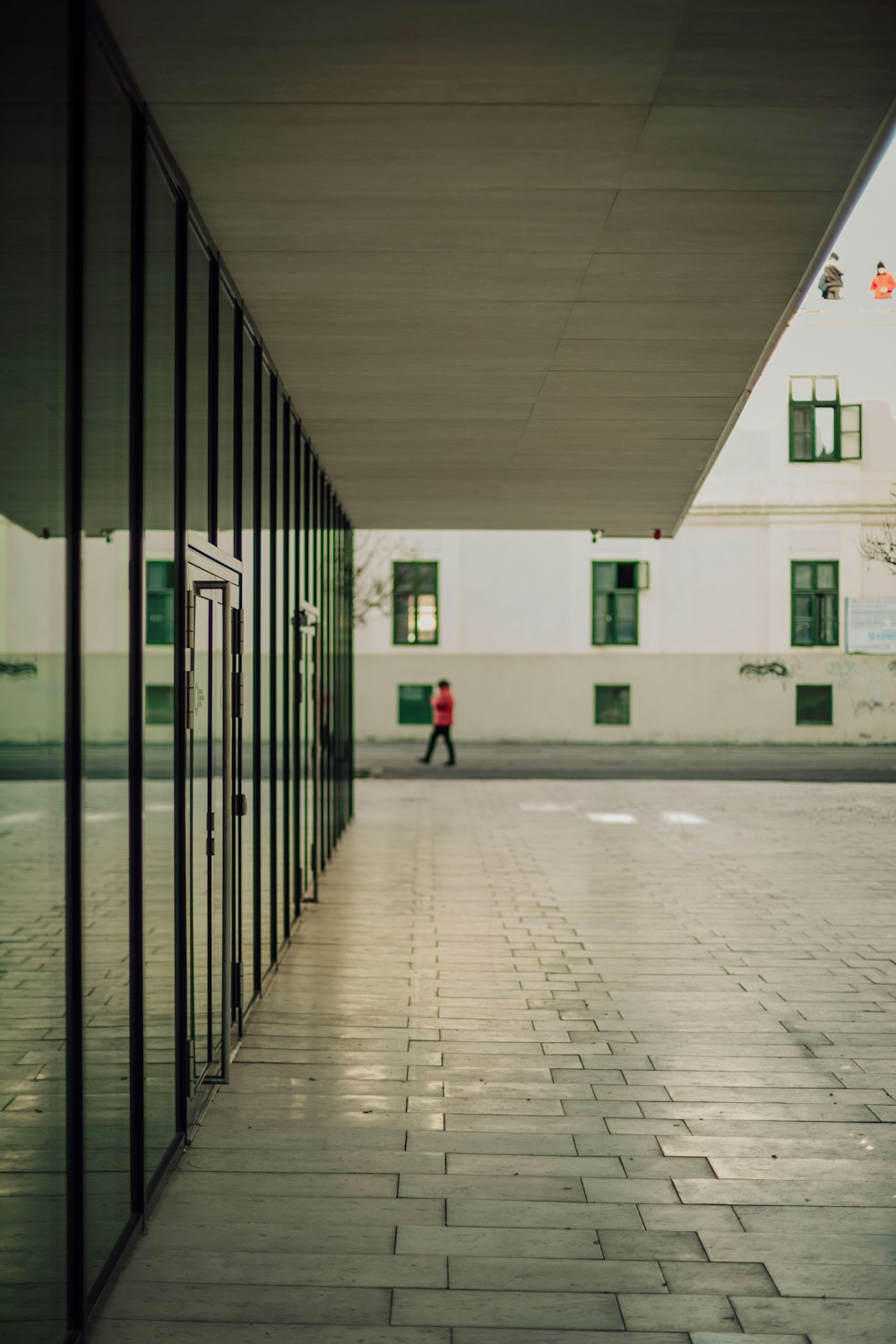 a person walking down a hallway between two buildings