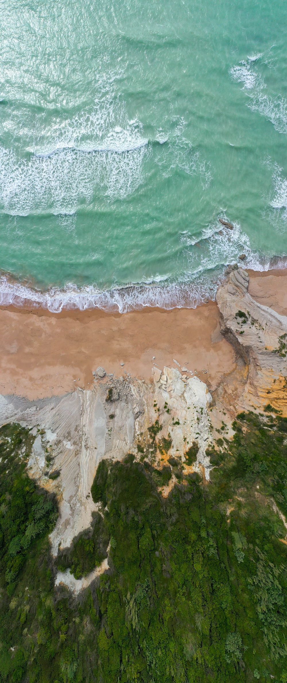 an aerial view of a sandy beach and ocean