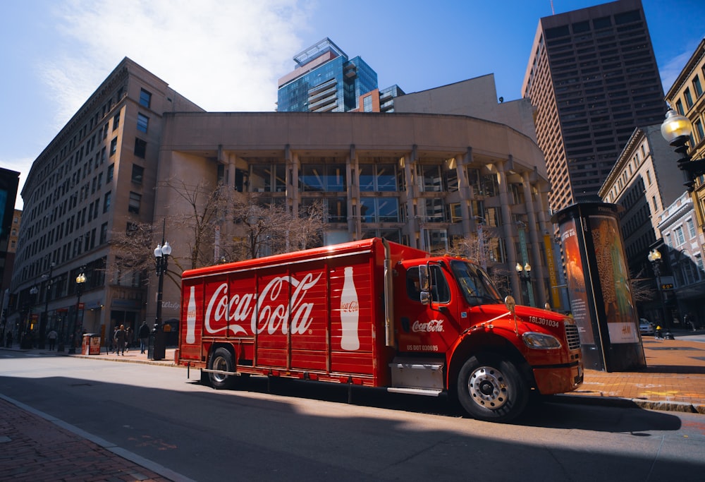 a coca - cola truck is parked in front of a building