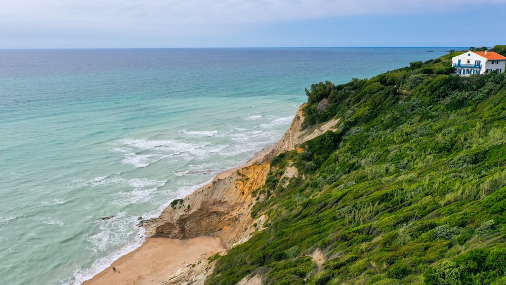 a house sitting on top of a cliff next to the ocean