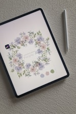 A tablet displaying a colorful worksheet with soft pastel accents and floral borders.