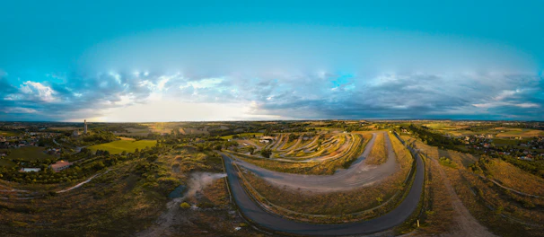 A panoramic view of rolling hills dotted with tribal settlements at sunset.
