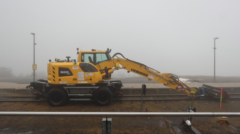 a yellow tractor is parked on the tracks