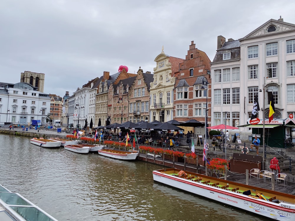 several boats are parked along the side of a river