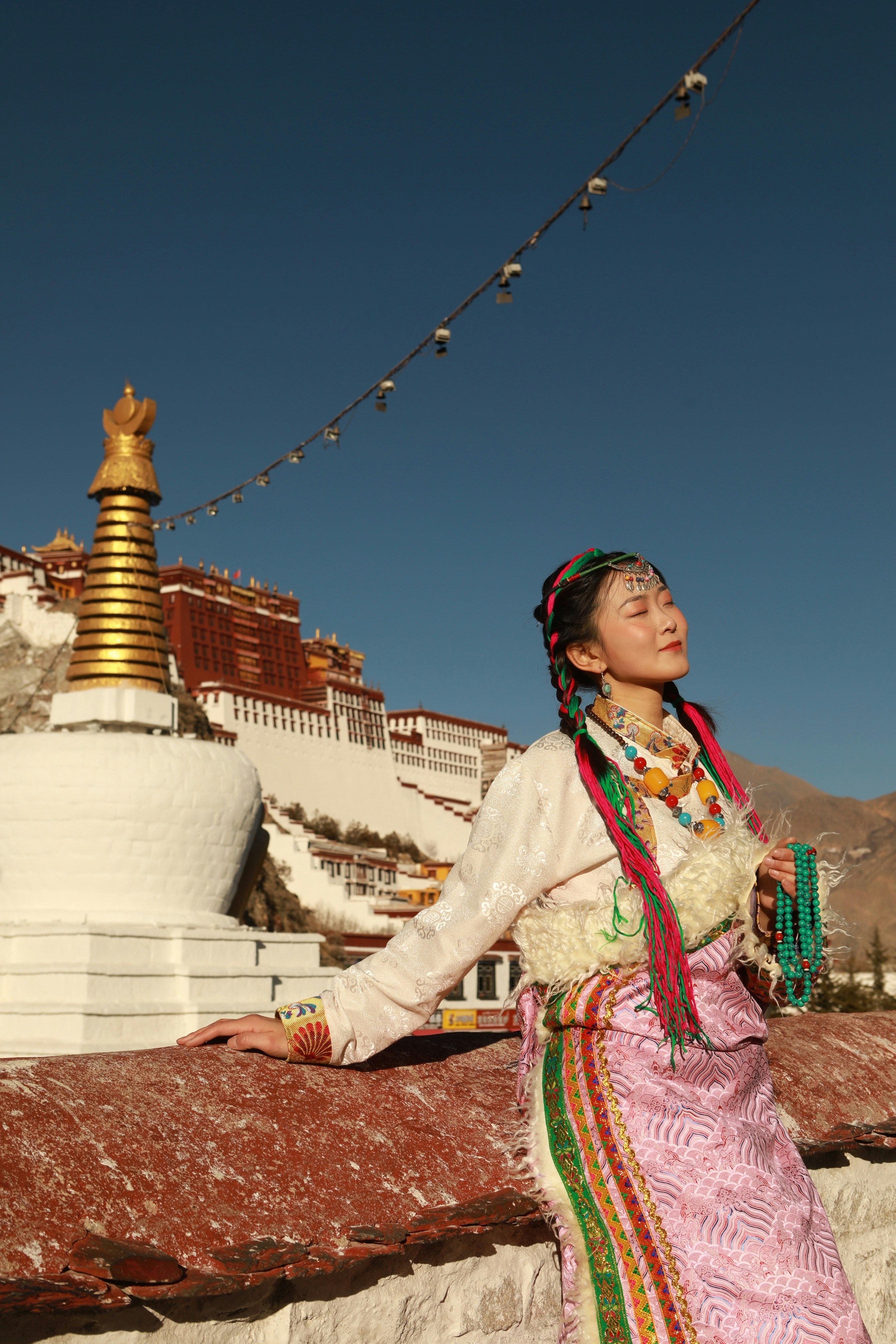 Una mujer parada en una repisa frente a un edificio