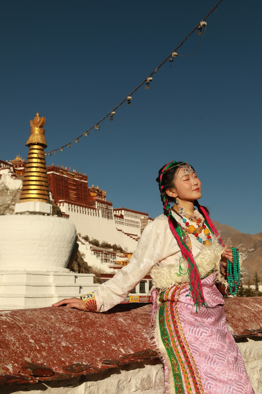 a woman standing on a ledge in front of a building