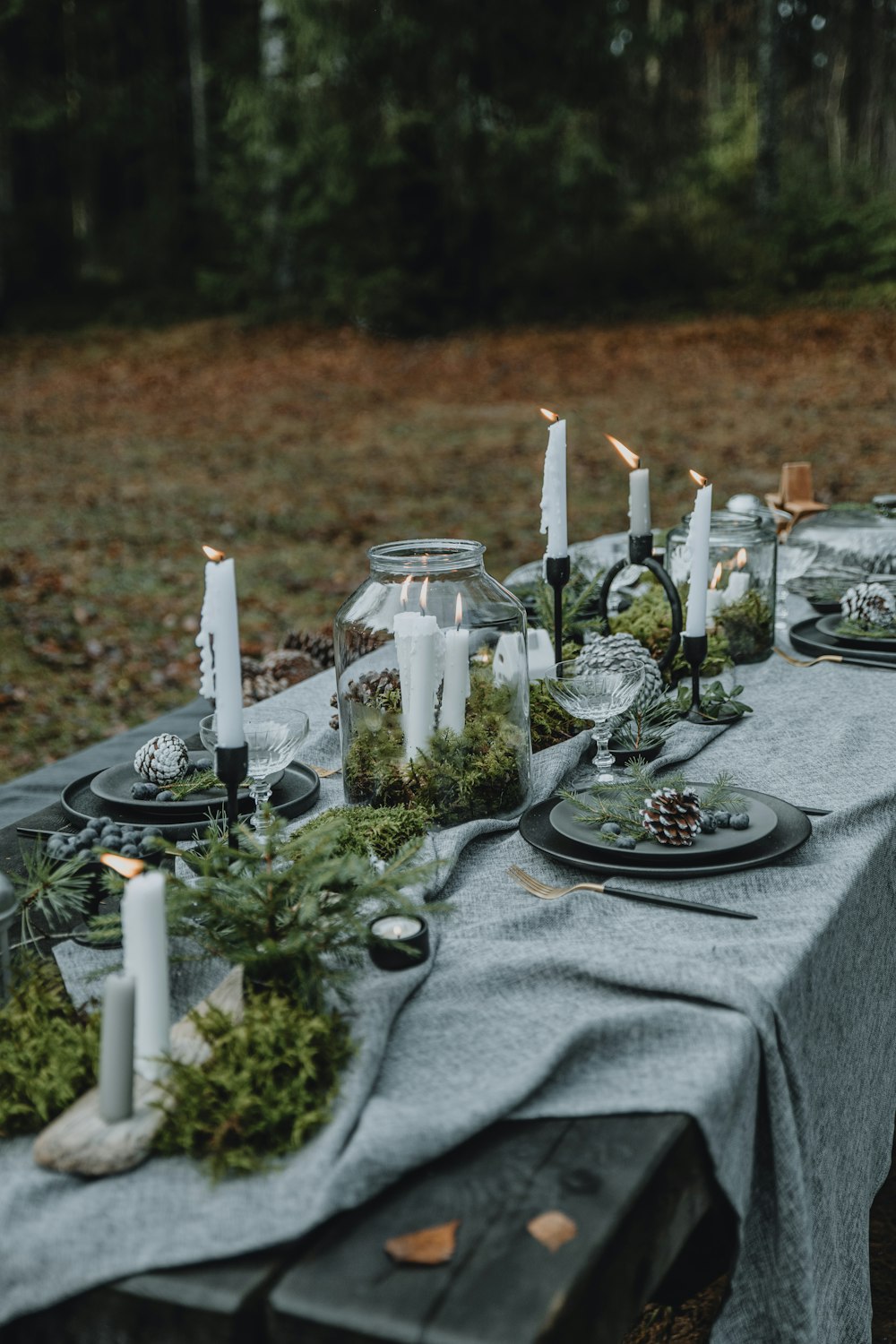 a long table with candles and plates on it