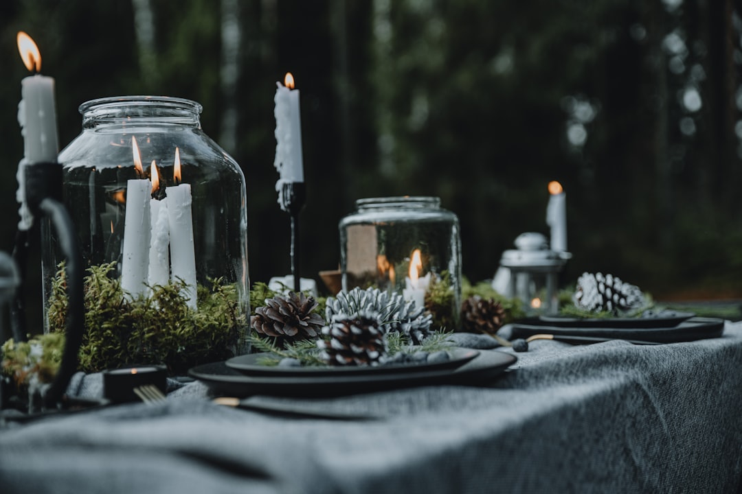 a table topped with candles and plates covered in moss,