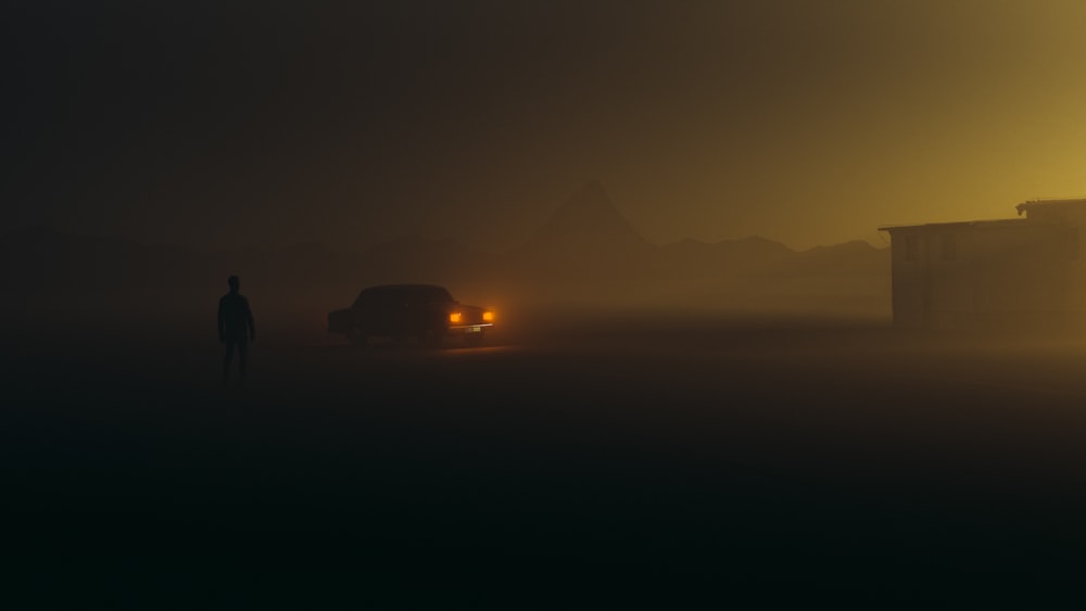 a man standing next to a car on a foggy road