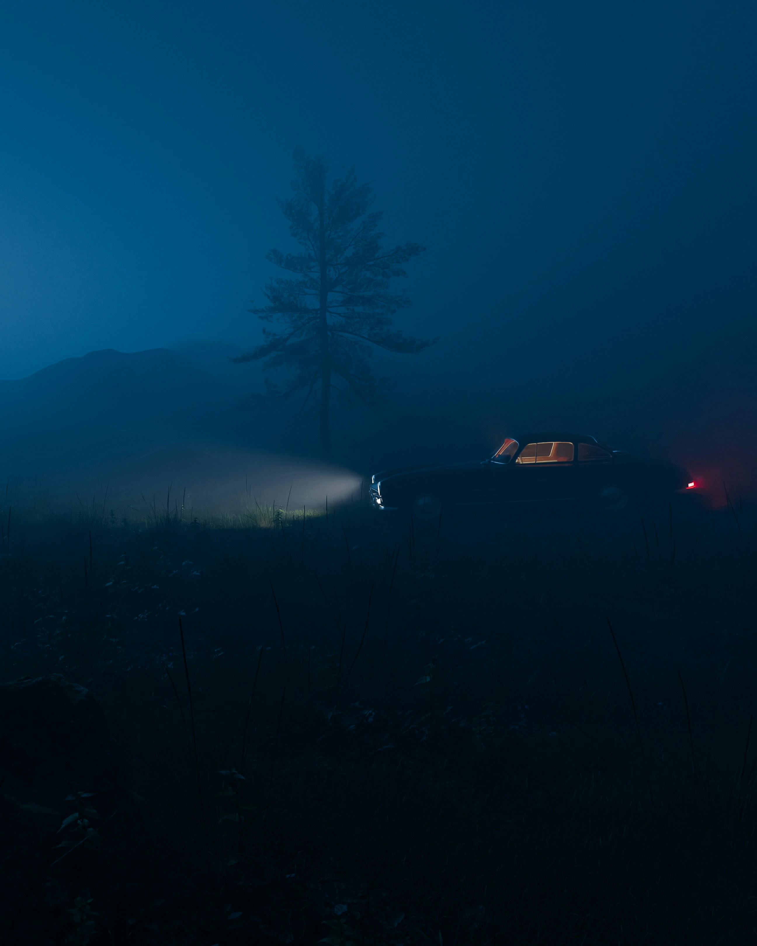 a car driving on a foggy road at night