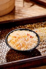 a wooden tray with a bowl of rice on top of it