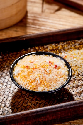a wooden tray with a bowl of rice on top of it