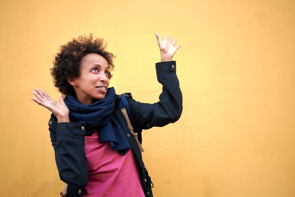 a woman standing in front of a yellow wall