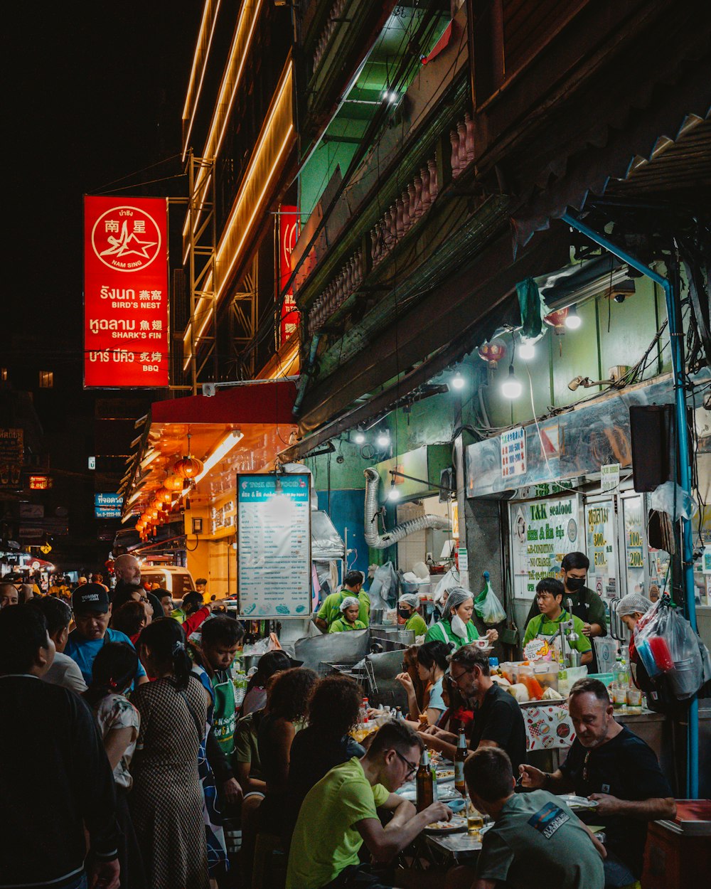 a group of people sitting at a table outside of a restaurant