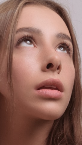 Close-up of a professional woman with flawless skin and natural lighting.