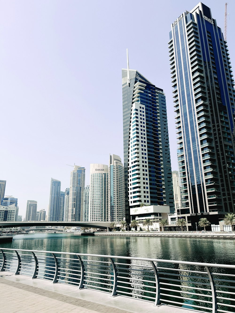 a view of some very tall buildings by the water