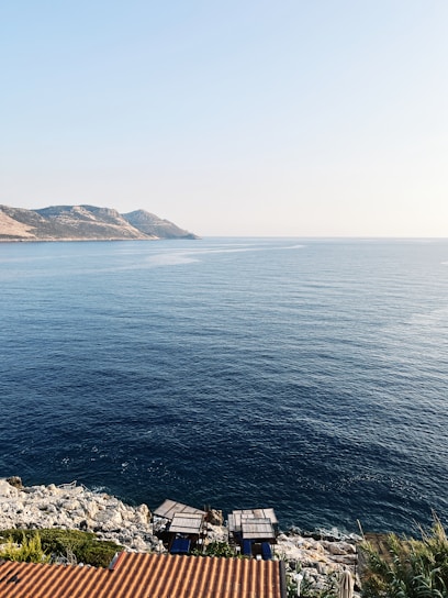 A serene coastal scene with a consultant discussing sustainability plans with a client by the water.