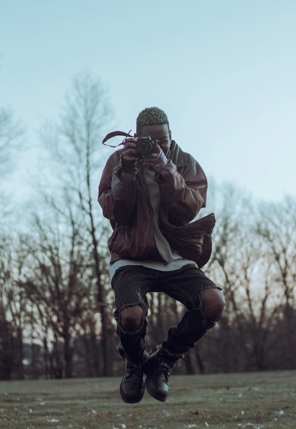 a man jumping in the air while holding a camera