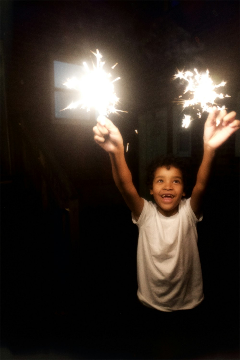 a young boy holding two sparklers in his hands