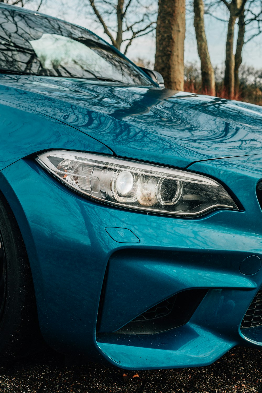 a blue bmw car parked in a parking lot