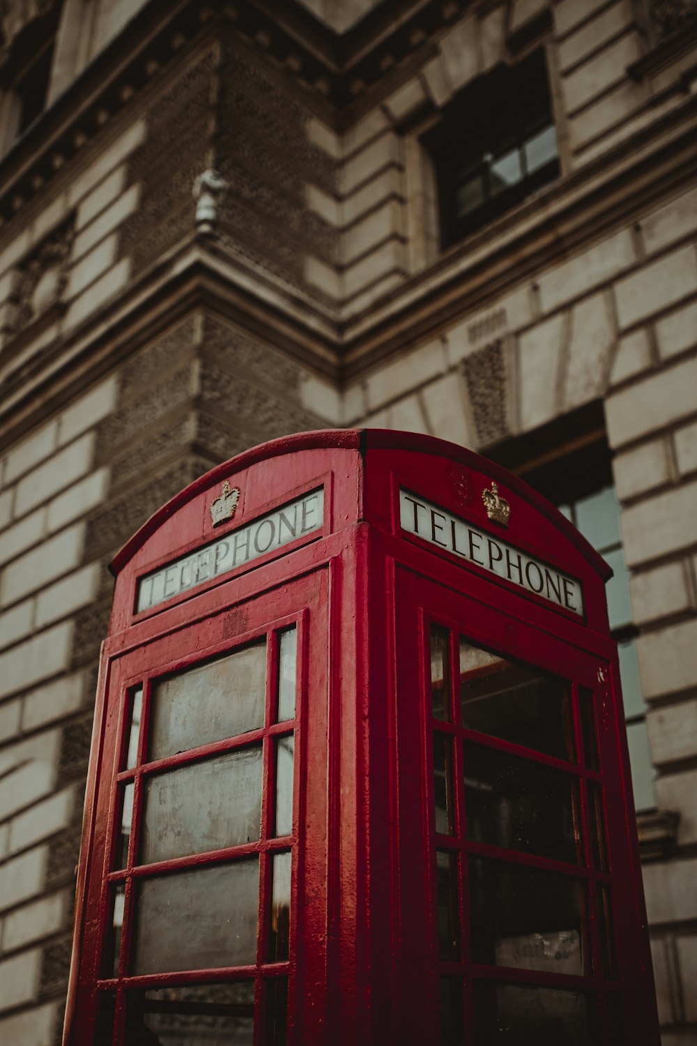 a red telephone booth in front of a building