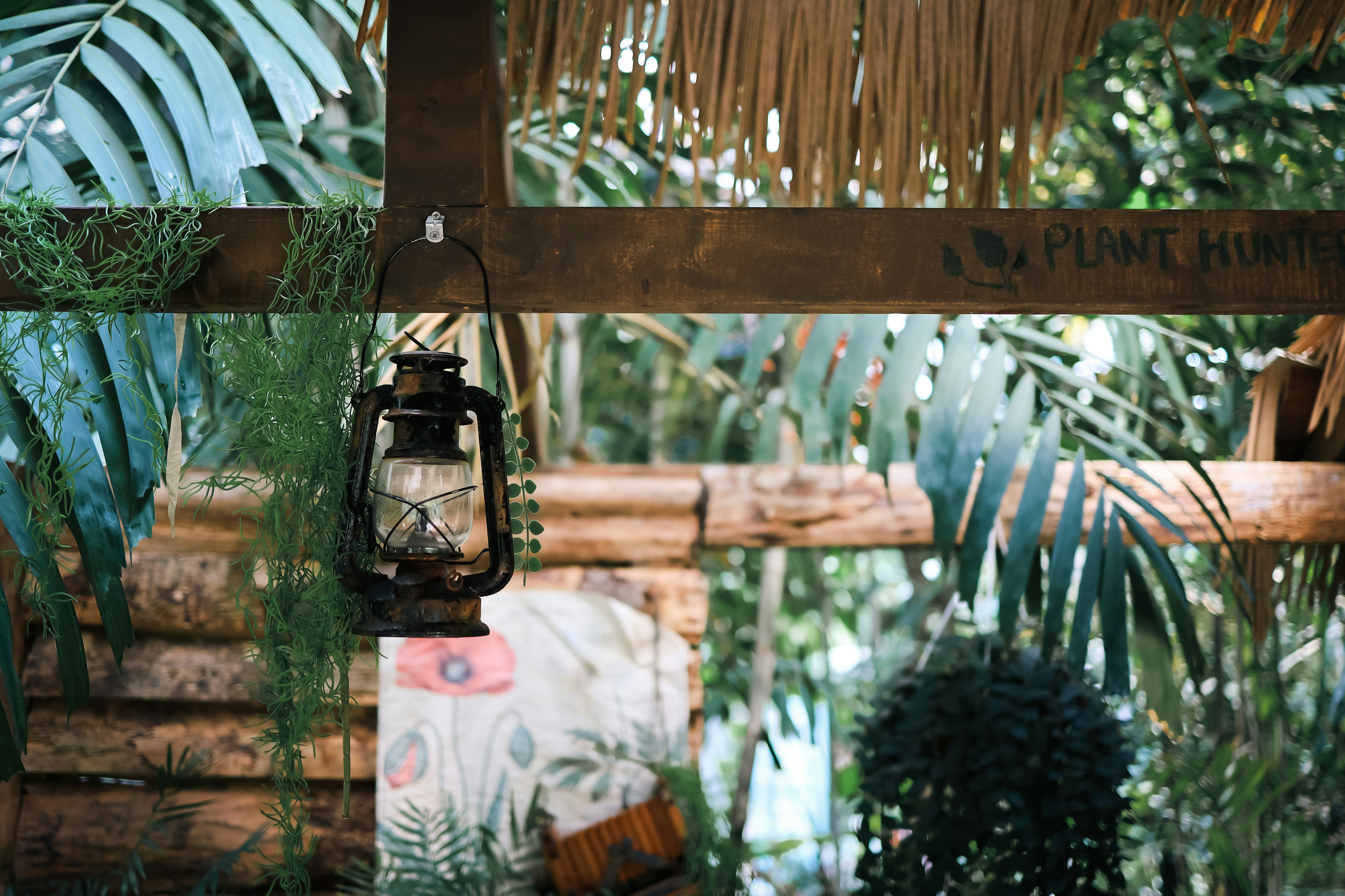 Une lanterne suspendue à une poutre en bois dans un décor tropical