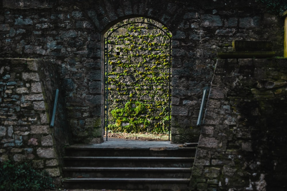 a stone wall with a doorway and steps leading to it