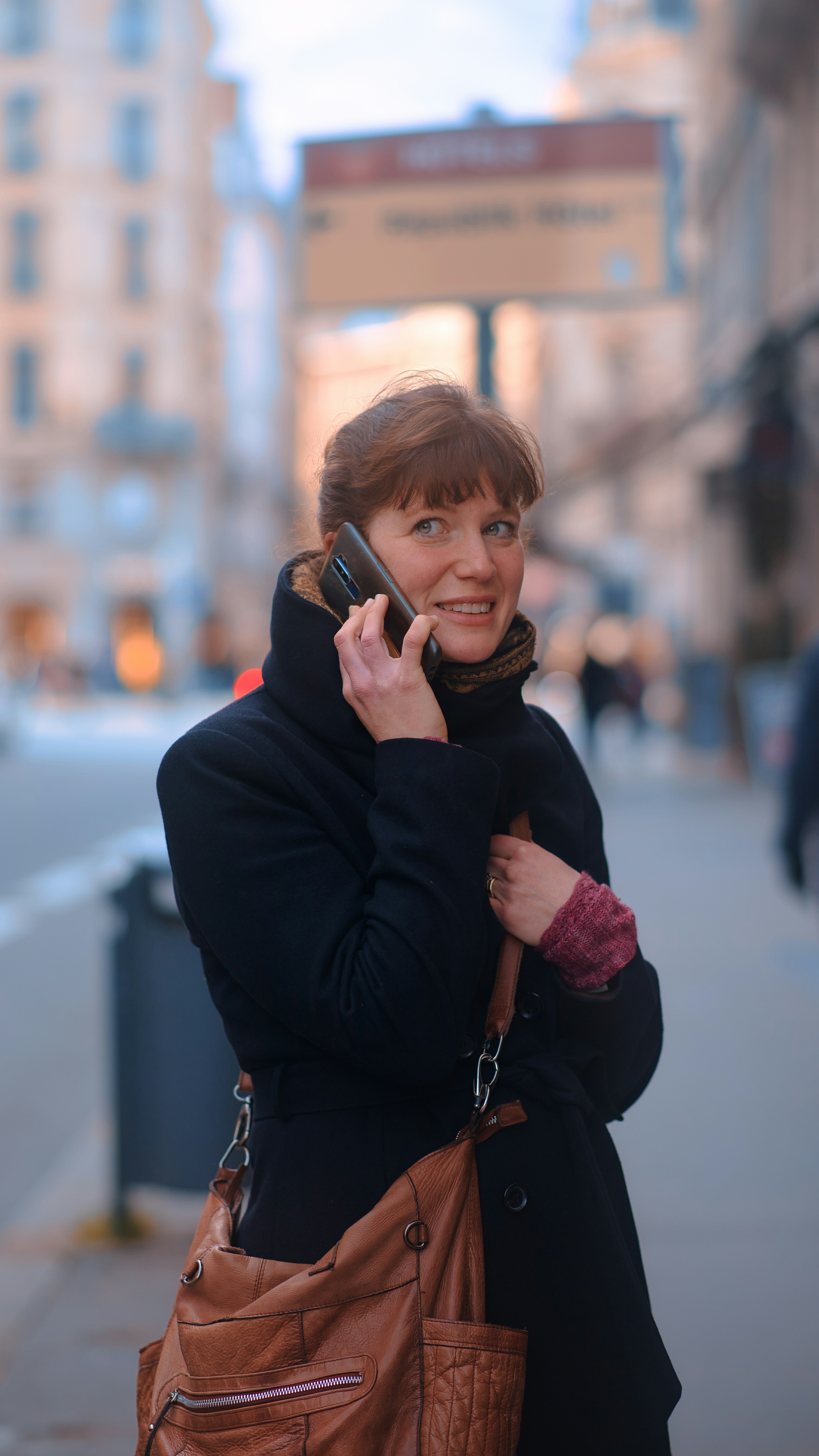 a woman talking on a cell phone while holding a purse