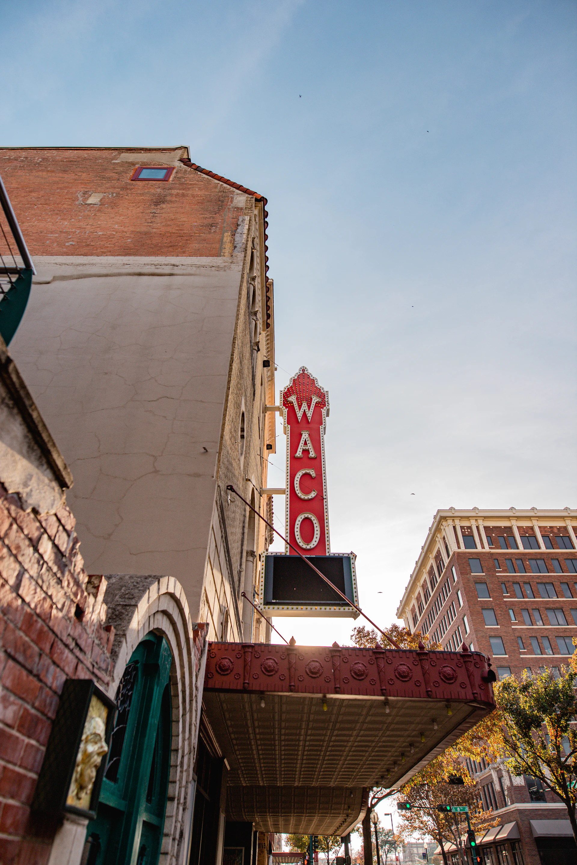 a red neon sign hanging from the side of a building