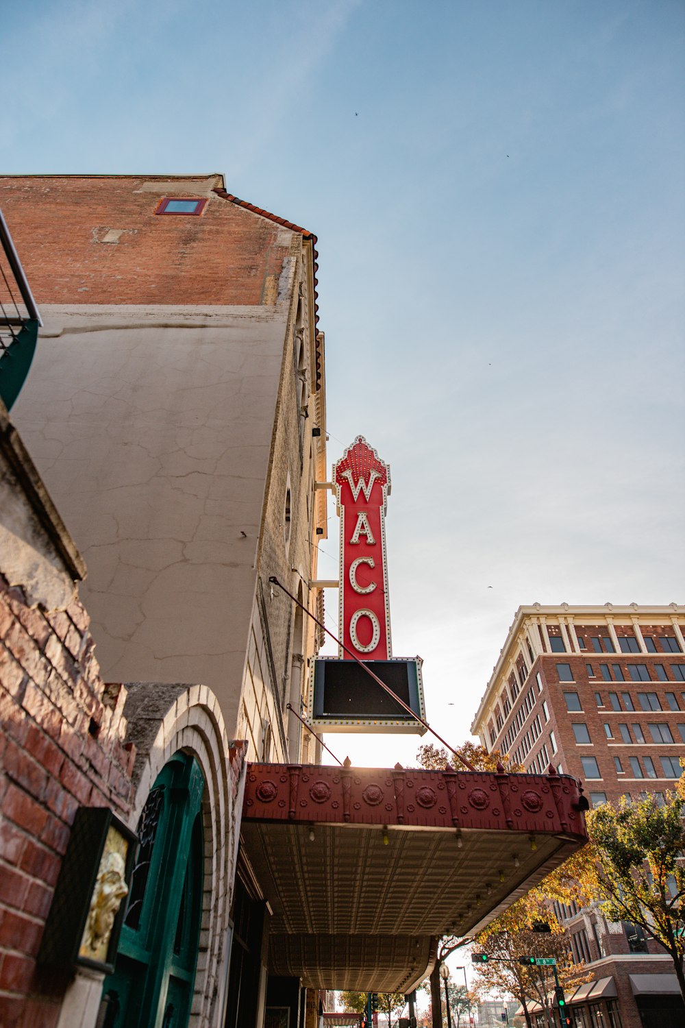 a red neon sign hanging from the side of a building