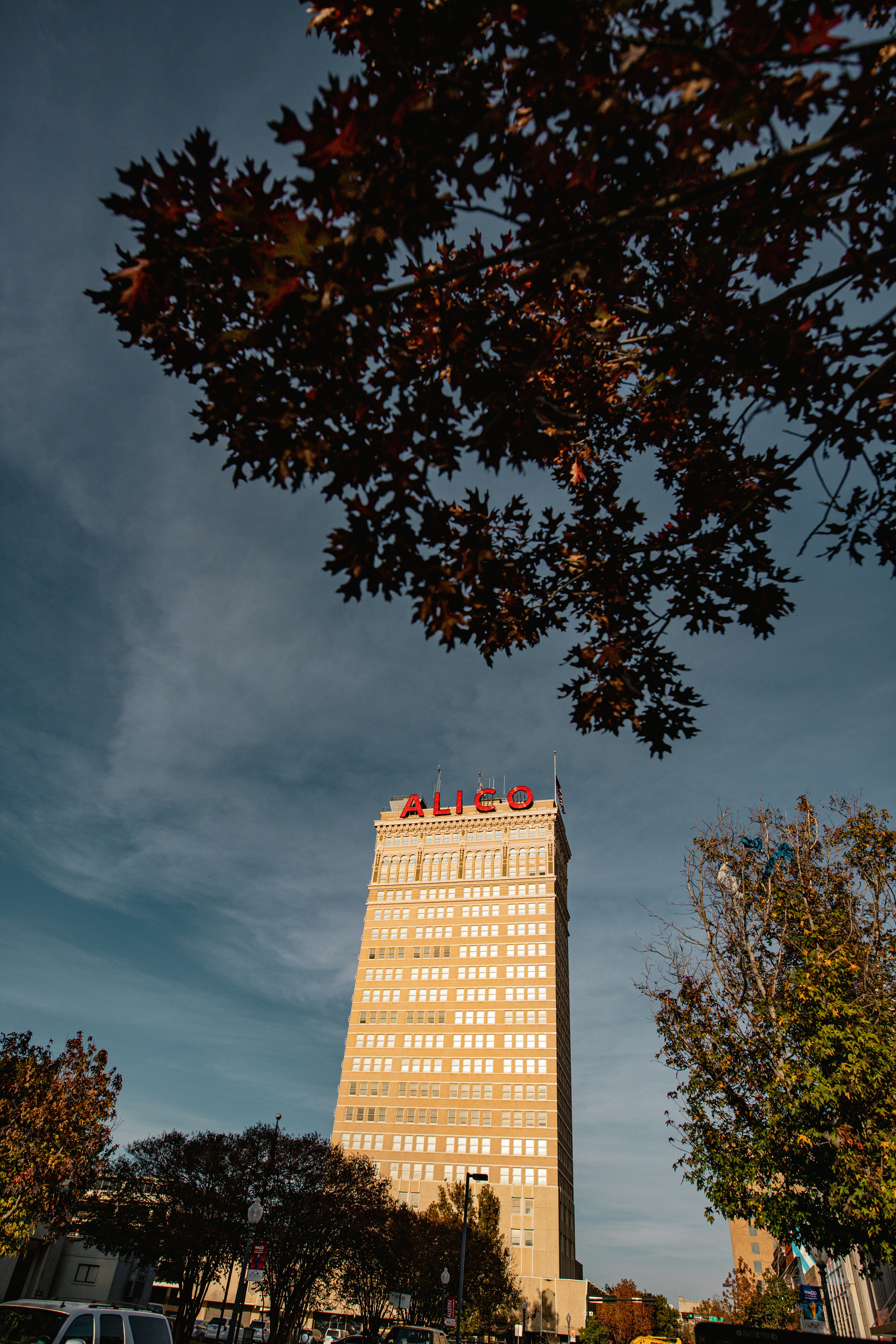 um edifício alto sentado ao lado de um estacionamento